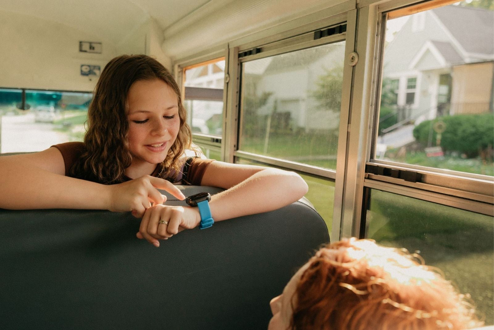 Girl on the school bus checking her Cosmo watch